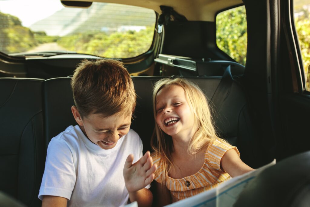 Kids having fun with road trip games in the back seat